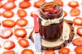 Jar of jam with pieces of fruit, made with organic and natural strawberry. Blurred sliced Ã¢â¬â¹Ã¢â¬â¹strawberries in the background